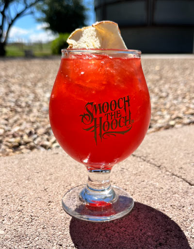 In belgium glass over ice add whiskey and Grenadine and sprinkle in luster dust. Top off with equal parts apple cider and cranberry juice. Garnish with dried apple.